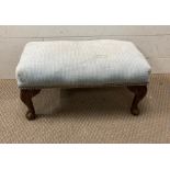 A blue upholstered foot stool on oak cabriole legs