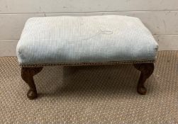 A blue upholstered foot stool on oak cabriole legs
