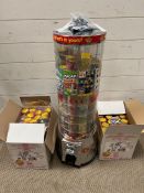 A rotating coin operated sweet dispenser with boxes of sweets