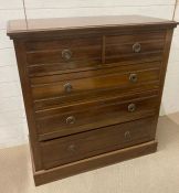 An oak two over three chest of drawers with drop down handles (H104cm W100cm D46cm)