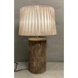 A rustic wooden tree trunk effect table lamp