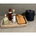 A rattan bar tray with cocktail shaker, leather ice bucket, a bottle of Daylesford Gin, A bottle