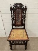 An oak caned and barley twist hall chair with cane to seat and back along with carved back and