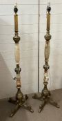 A pair of faux marble and metal floor standing lamps