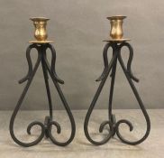 A pair of wrought iron and brass top candle sticks