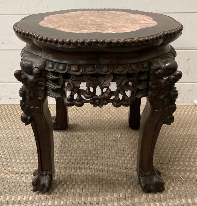 An antique Chinese carved hardwood stand with marble top