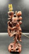 A carved wooden figural lamp