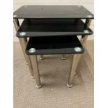 A set of black chrome and glass nesting tables