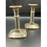 A pair of white metal telescope candlesticks on rectangular bases and crowns (H17.5cm)