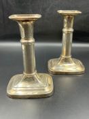 A pair of white metal telescope candlesticks on rectangular bases and crowns (H17.5cm)