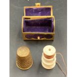 A vintage brass thimble in a brass trunk styled holder.