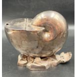 A shell shaped white metal sugar bowl.