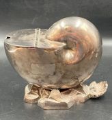 A shell shaped white metal sugar bowl.