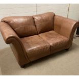Two seater leather sofa on turned feet