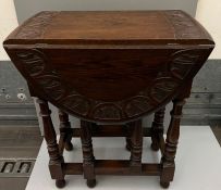 An oak drop side table with carved detail (H73cm W52cm D35cm)