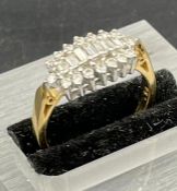 A Diamond ring with seven graduated baguette cut diamonds with sixteen smaller diamonds