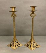 A pair of brass of Art Nouveau style candle sticks