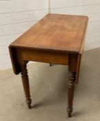 A light oak drop leaf table on turned legs with drawer to side (W94cm D50cm H70cm)