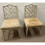 A pair of faux bamboo chairs with cane seats