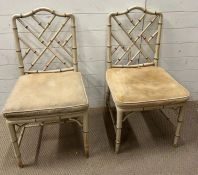 A pair of faux bamboo chairs with cane seats