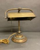 An antique brass bankers lamp with adjustable shade