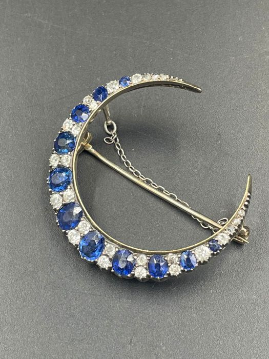 A Sapphire and diamond brooch with eleven graduated sapphires, each stone separated by diamonds.