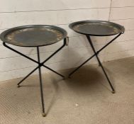 A pair of collapsible metal side tables with painted leaf details