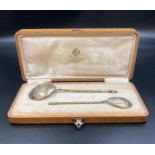 A Boxed pair of silver gilt engraved spoons in original oak box. Early 20th Century Russian.