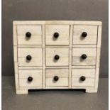 A nine drawer white jewelry or sewing box