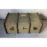 A antique canvas covered wooden banded travel trunk