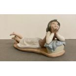 A Nao figurine of a girl lying down blowing a kiss