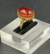 A Carnelian ring set in yellow gold marked 750. (Approximate Total Weight 8.7g) Size M
