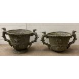 A pair of lead garden planters with cherub detailing and griffin handles (One is missing its