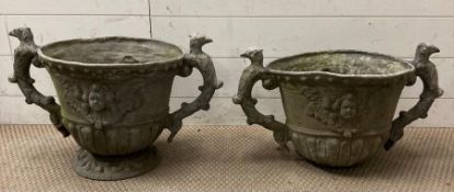 A pair of lead garden planters with cherub detailing and griffin handles (One is missing its
