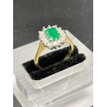 An 18ct yellow gold set emerald and diamond ring Size O