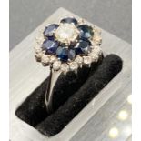 A diamond and sapphire cluster ring, on 18k white gold.