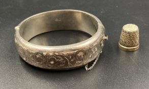 A silver bracelet and a thimble