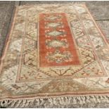 A wool Turkish rug with white background and orange boarder (296cm x 198cm)