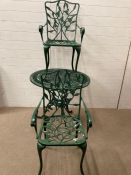 A wrought iron painted green bistro set
