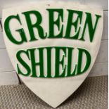 A vintage green shield advertising sign in plaster