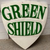 A vintage green shield advertising sign in plaster