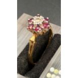 A ruby and diamond ring in a daisy style with central diamond surrounded by six rubies (