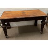 A mahogany console table, the table top sits above frieze of carved wood raised on tapering turned