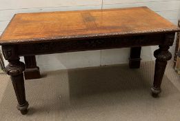 A mahogany console table, the table top sits above frieze of carved wood raised on tapering turned