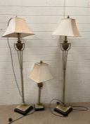 A pair of contemporary floor lamps and a matching table lamp with urn details