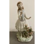 A Lladro porcelain figurine of a girl smelling flowers