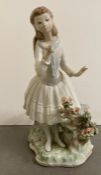 A Lladro porcelain figurine of a girl smelling flowers