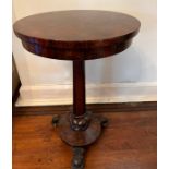 A rosewood side table on center leg terminating in three carved feet on castors