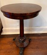 A rosewood side table on center leg terminating in three carved feet on castors