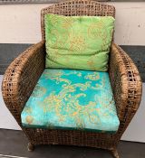 A wicker chair with Designers Guild cushions